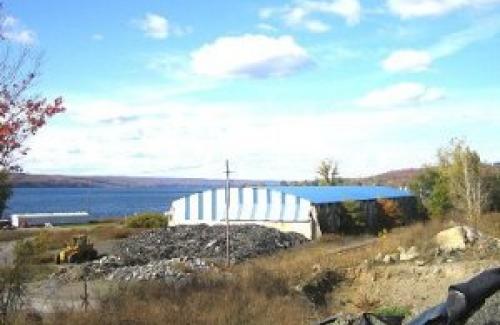 Portland Point cement works storage building; old, blue roof, blue skies, lake in background