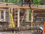 forklift placing logs onto top of cabin