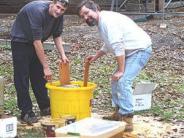 Men standing around a yellow pail