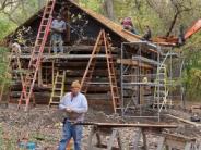 ladders up against log cabin, construction work being done