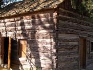 old log cabin, open cabin door, side view with window, shadow of a tree branch