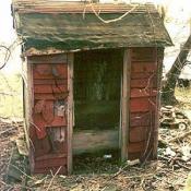 Old red slant roof outhouse