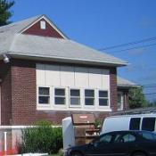 Lansing Community Library, Red brick bulding, row of windows in middle blue skies