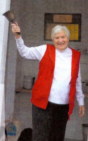 Louise Bement ringing bell at schoolhouse